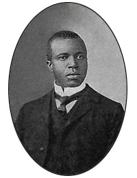 Monotone photo of man in black tie and suit.